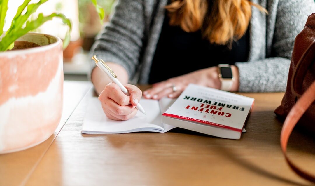 person writing goals in notebook