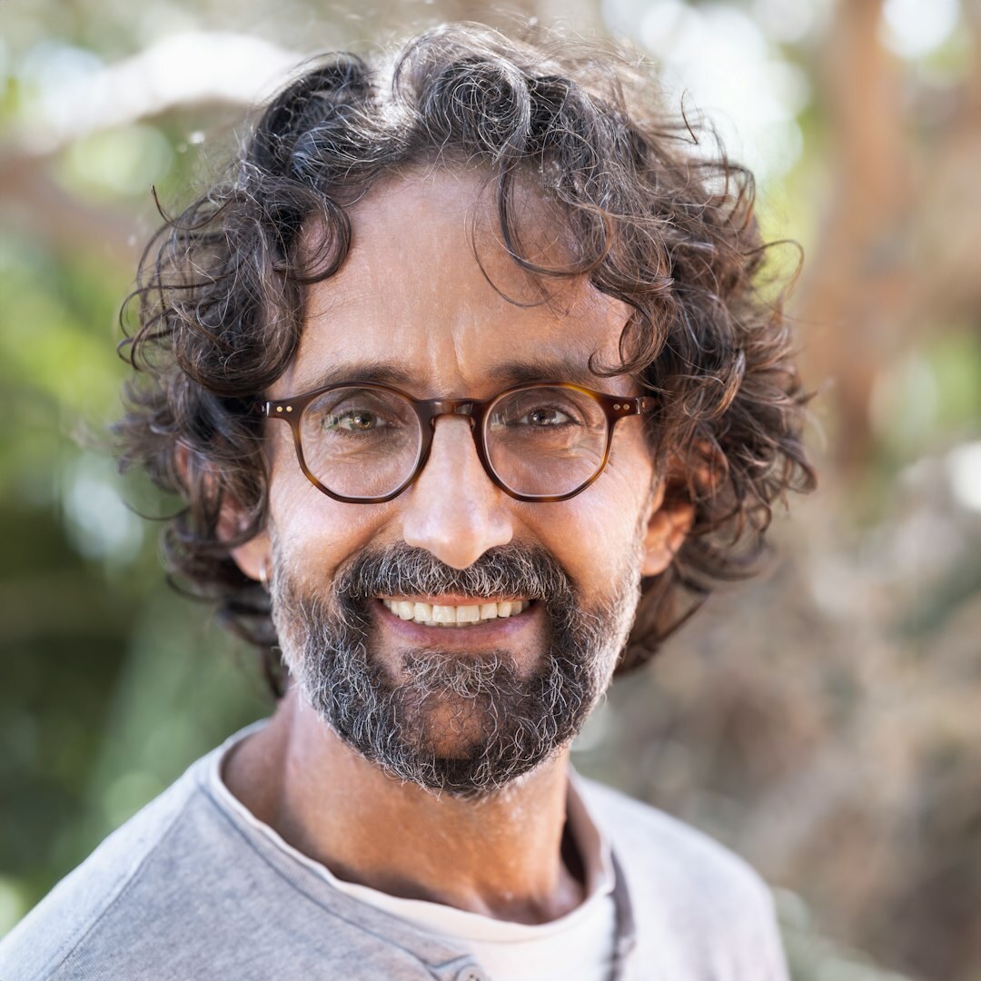 Brazilian man with curly hair, beard and glasses, portrait